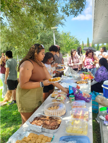 SOCA members serving and enjoying food from the potluck; Students learning from the University of South Florida’s Students for a Democratic Society Program.