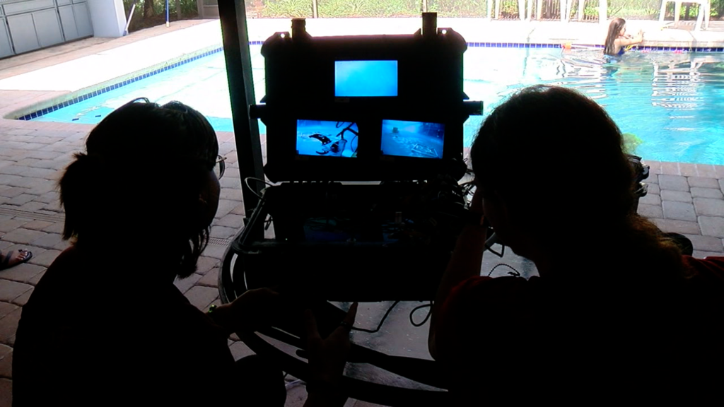 Robotics Team looking onto pool through monitors.